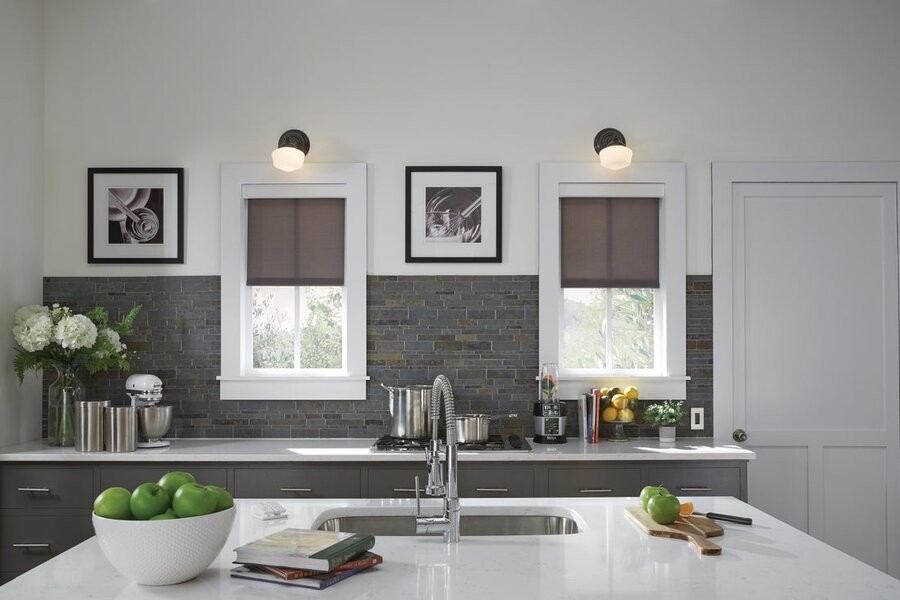 A kitchen space featuring motorized shades and lighting control fixtures.