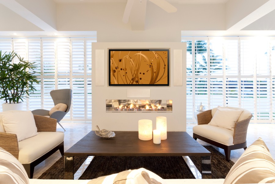 A living room featuring a wall-mounted TV and Paradigm speakers.