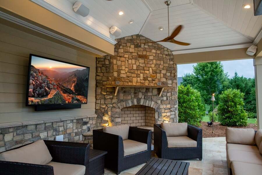 A luxurious roofed outdoor area with a Sunbrite TV.