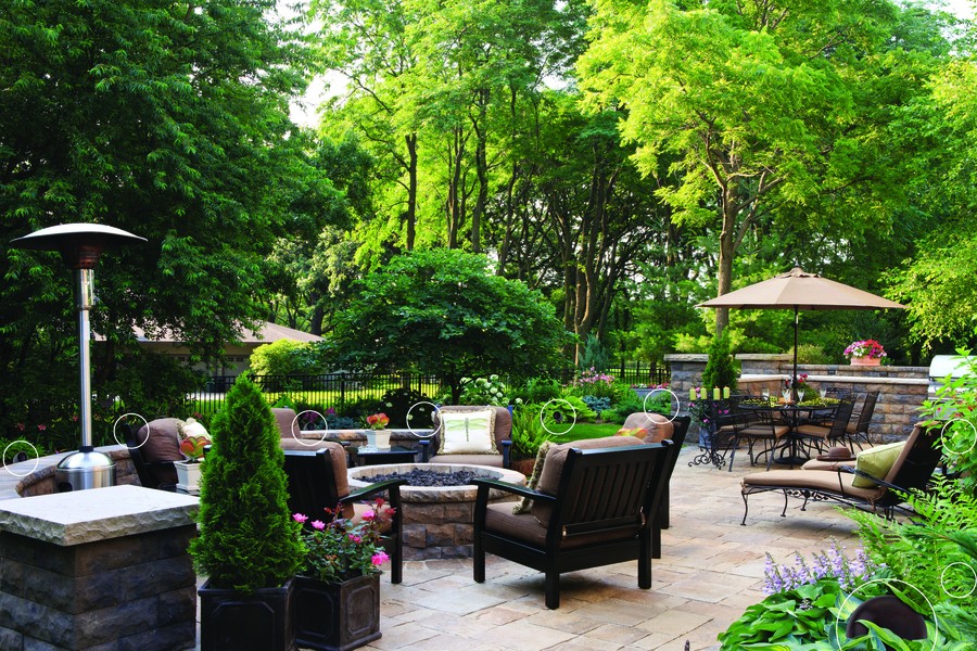 A backyard setting with seating around a firepit and hidden outdoor speakers circled to reveal them.