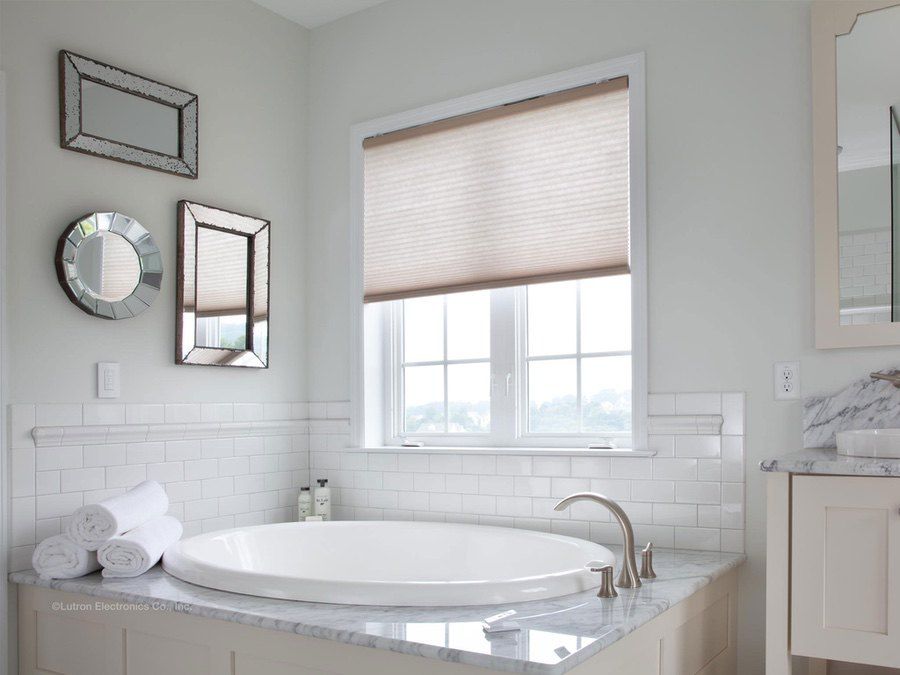 white bathtub in bathroom and lutron shades